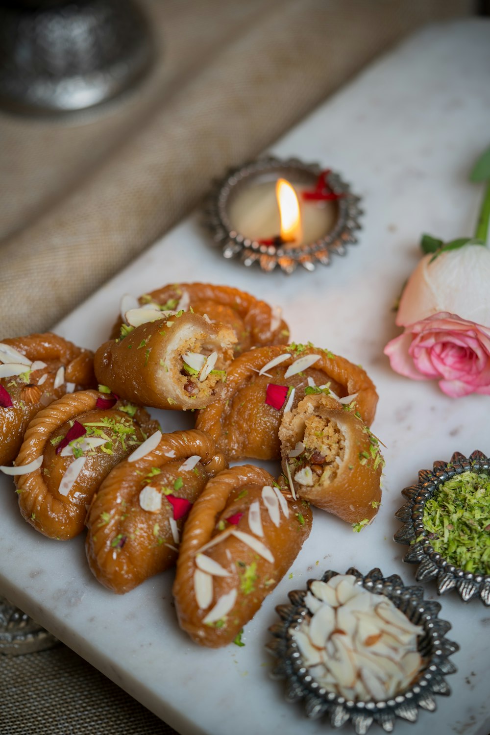 a white tray topped with assorted pastries next to a candle