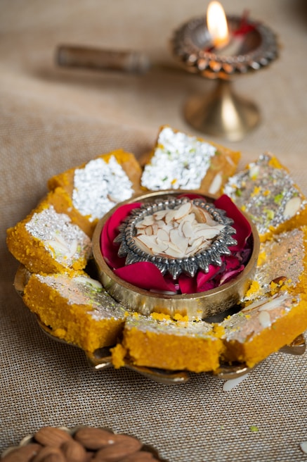 A close-up of rich, golden halwa on a decorative plate.
