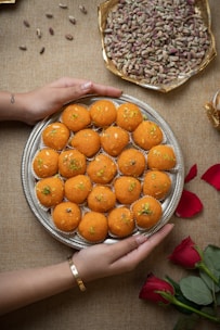 a person holding a plate of food on a table