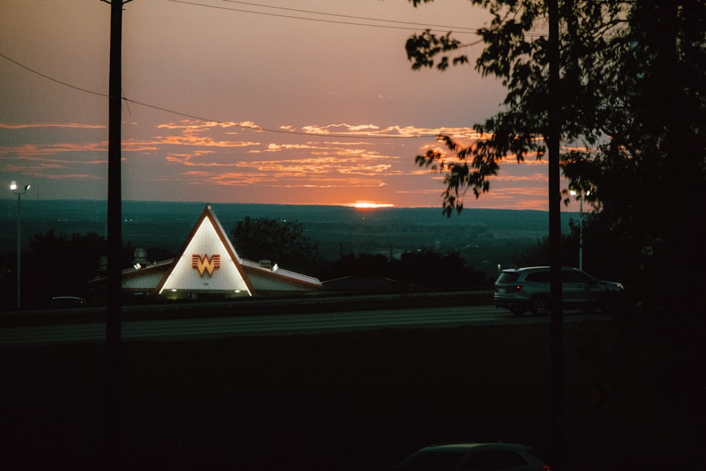 a triangle shaped building with a sunset in the background