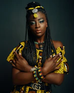Long jumbo braids decorated with yellow and red beads against gray background
