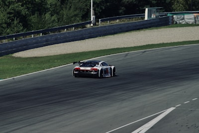 Side view of a sleek racing car flipping direction mid-air on a challenging platform track.