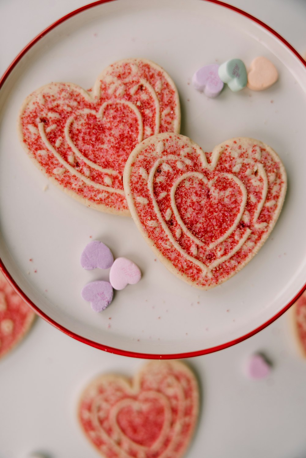 two heart shaped cookies sitting on top of a white plate