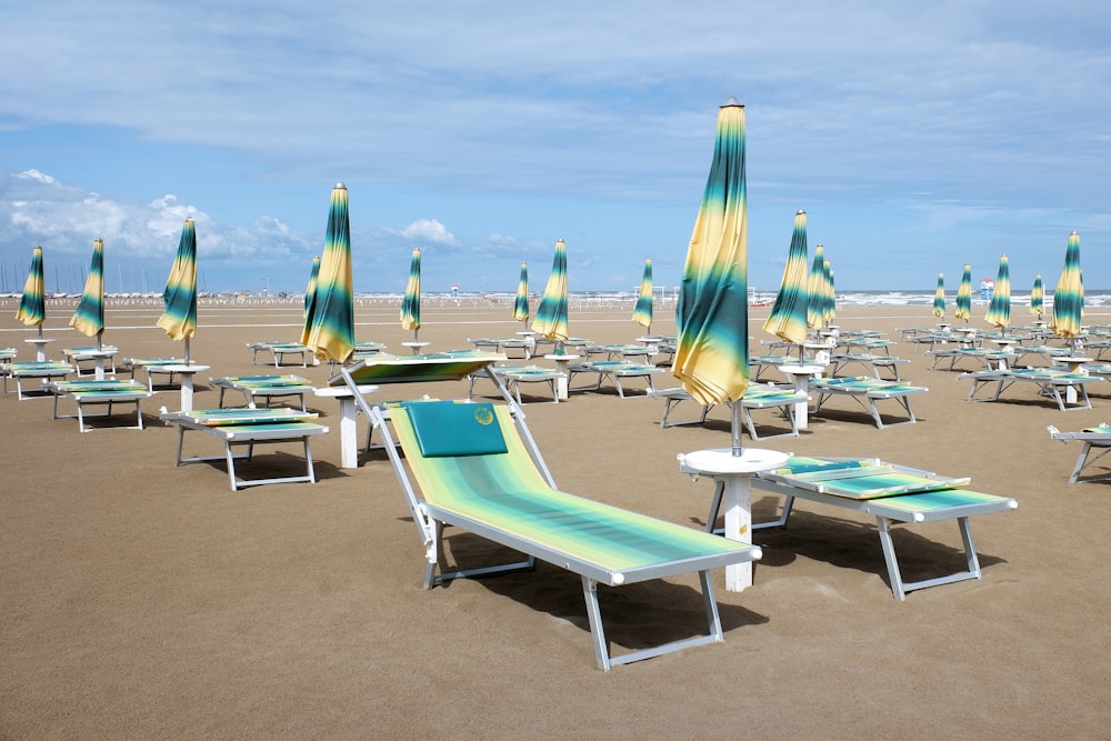 a bunch of lawn chairs and umbrellas on a beach