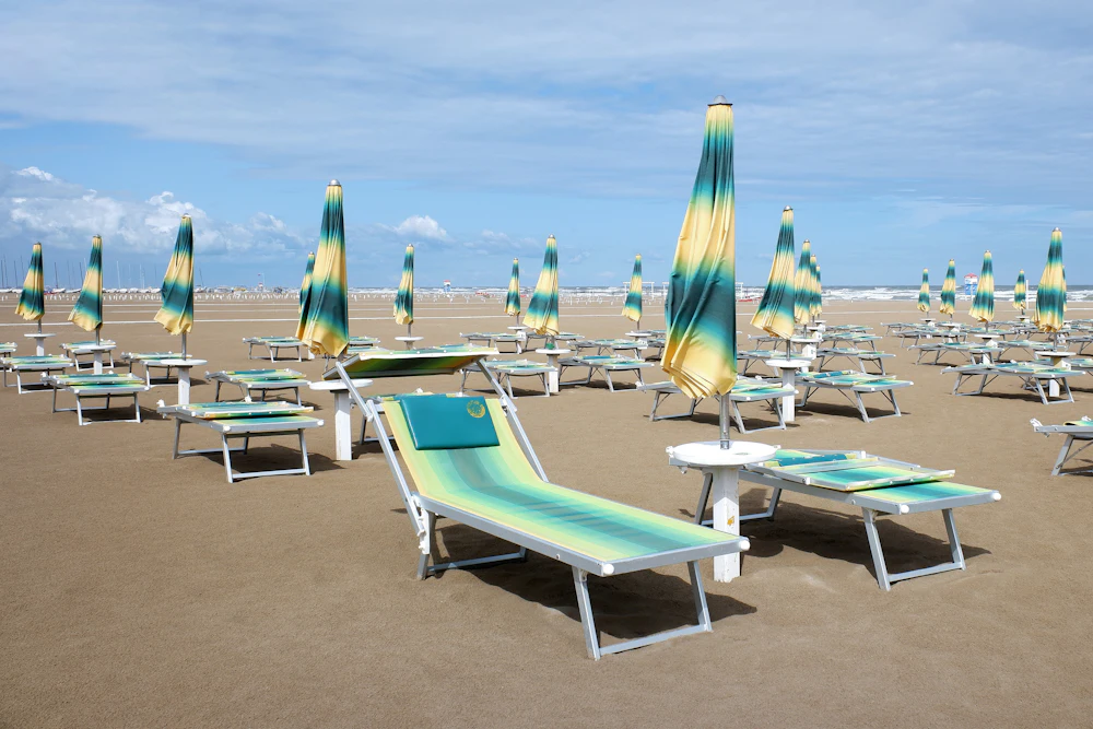 Rzędy leżaków i parasoli na szerokiej plaży w Rimini