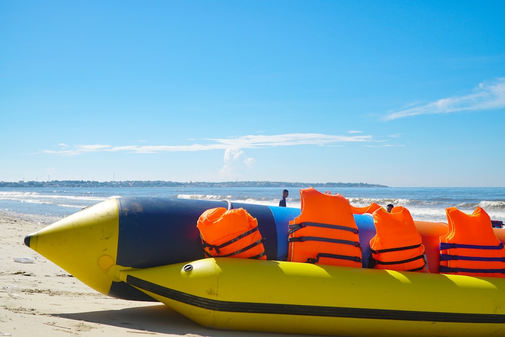 uma jangada inflável na praia com coletes salva-vidas