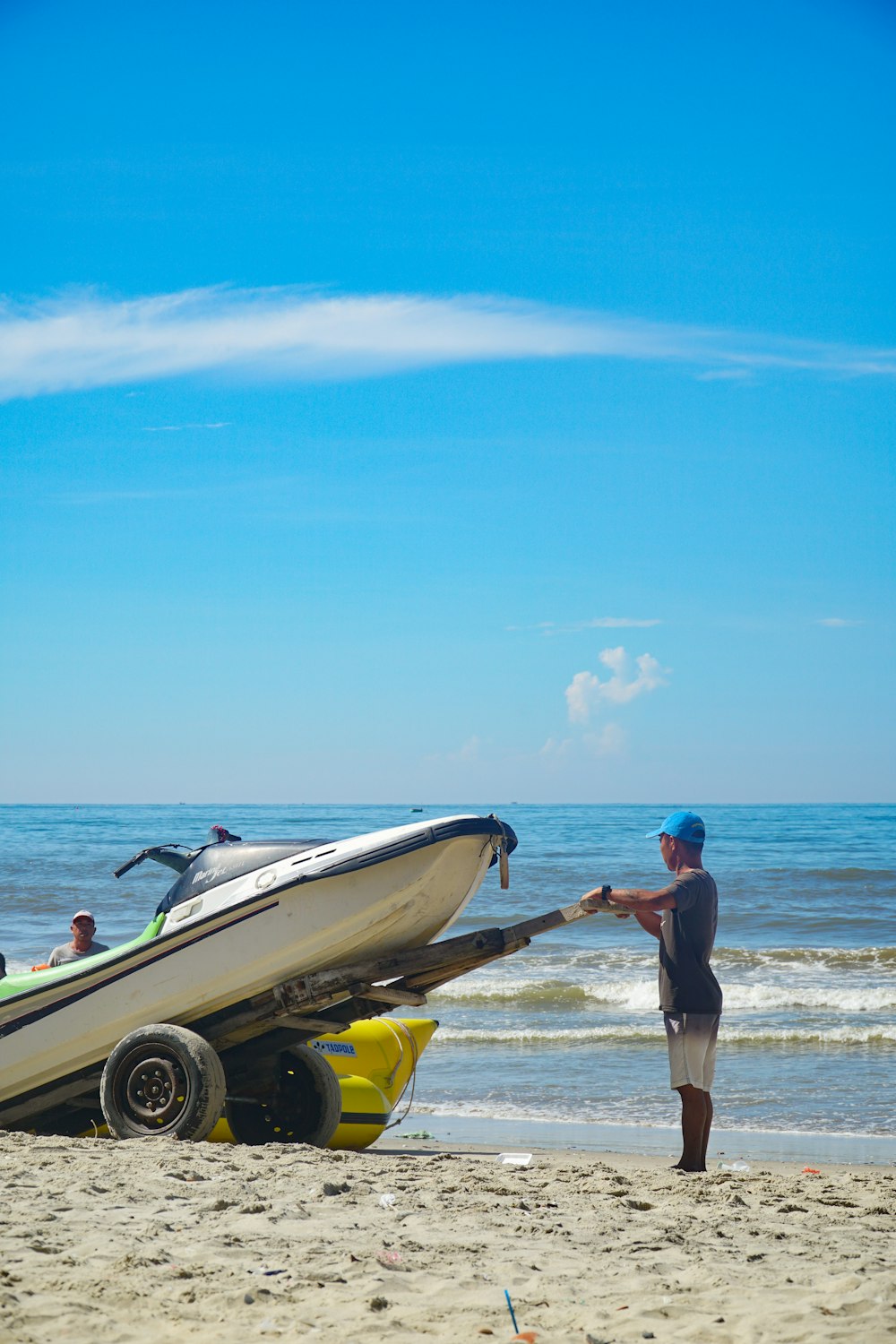 a man standing on a beach next to a boat