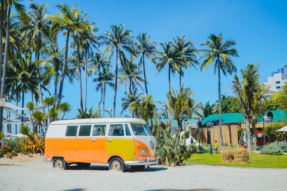 an orange and white van parked in front of palm trees