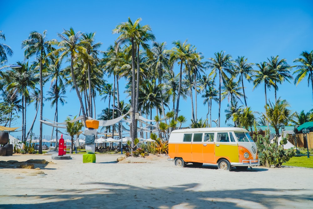 an orange and white van parked on a sandy beach