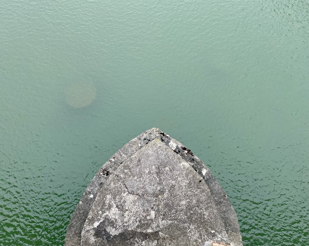 a large rock sticking out of the water