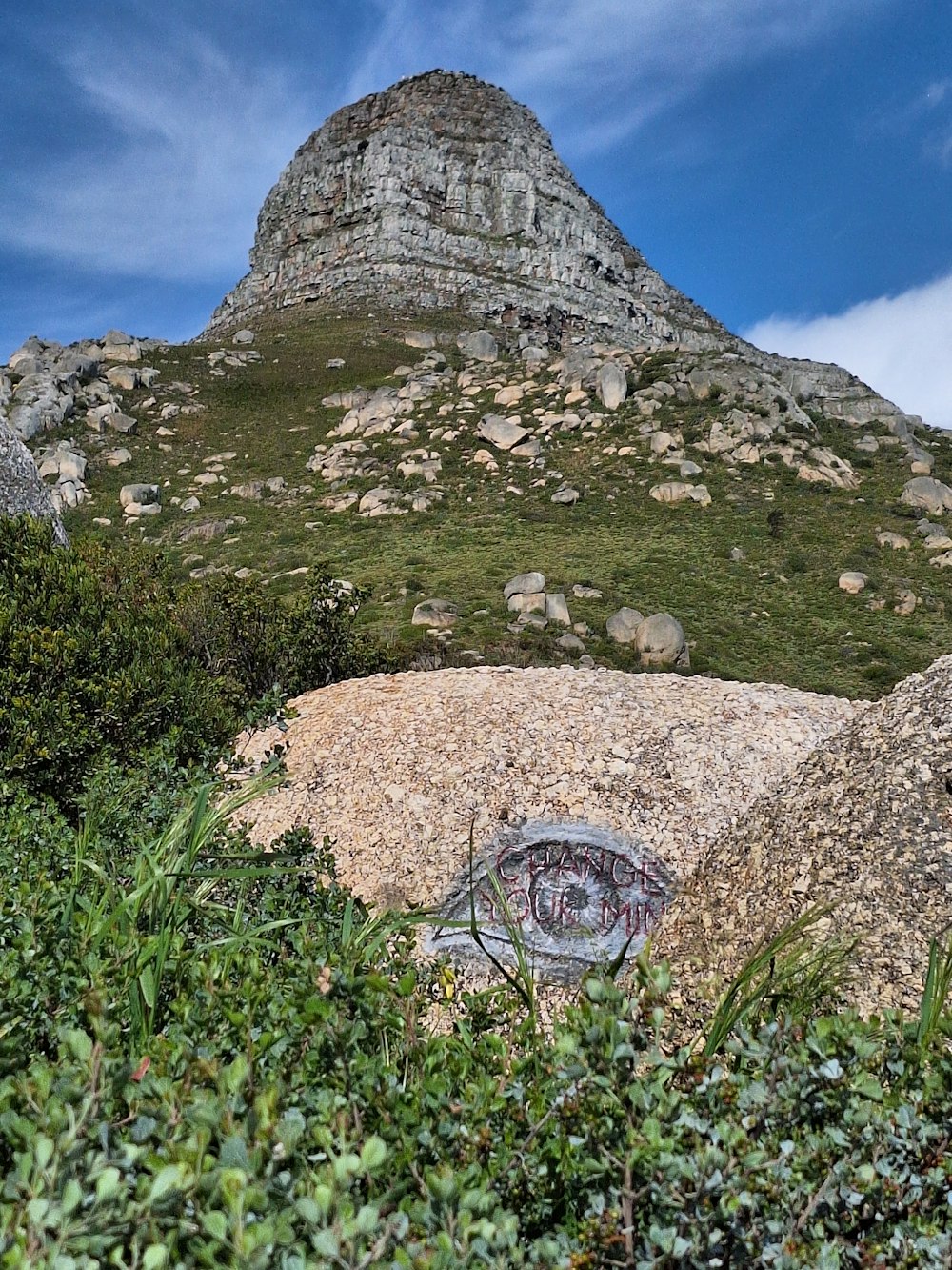 a rock with a graffiti on it near a mountain