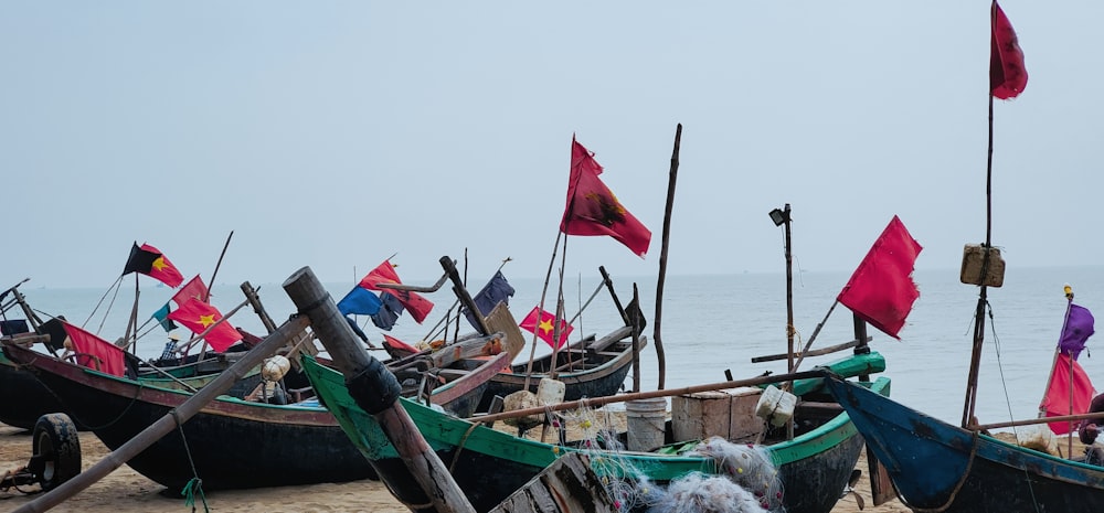 a group of boats sitting on top of a sandy beach