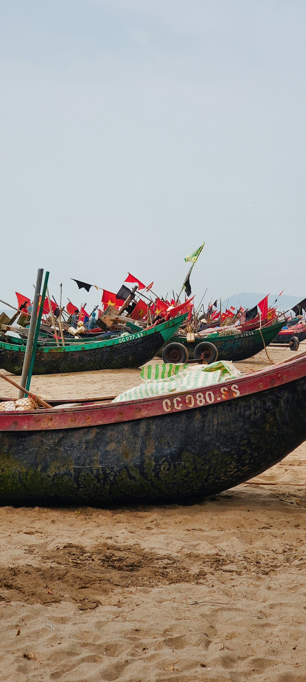 a group of boats sitting on top of a sandy beach