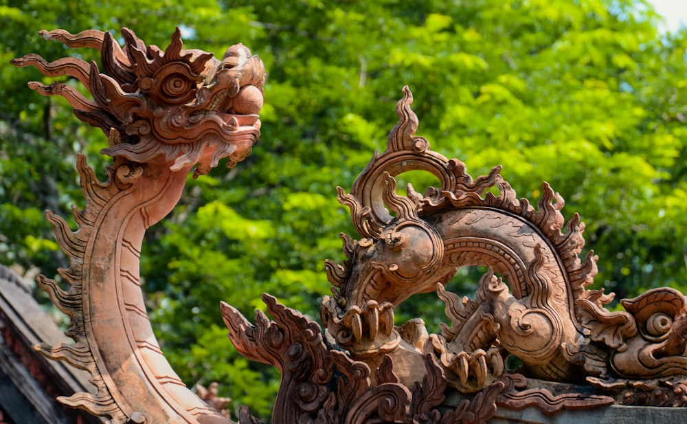 a close up of a dragon statue with trees in the background