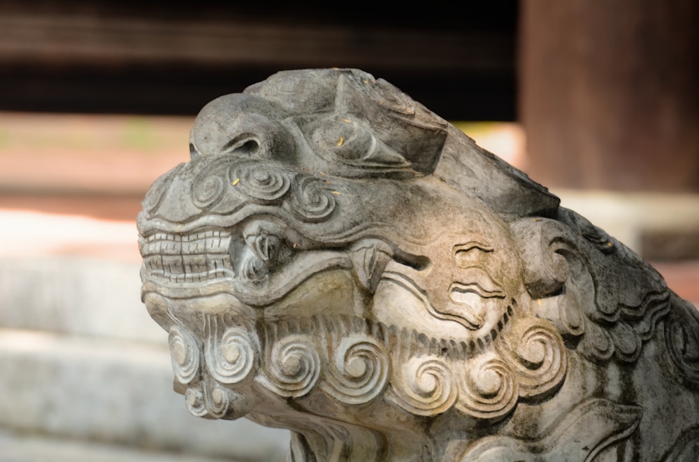 a stone statue of a lion with its mouth open