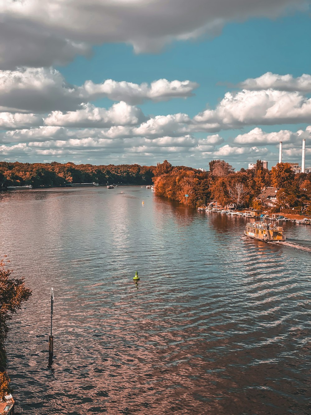 a body of water surrounded by trees and clouds