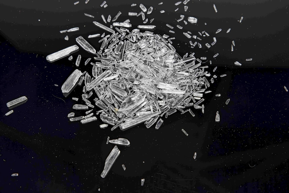 a pile of glass shards on a black surface