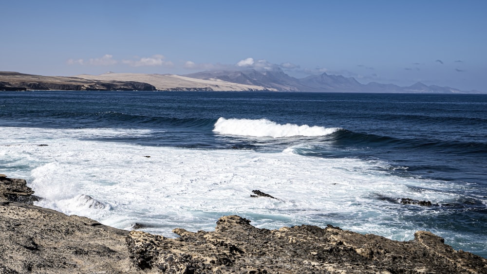 a large body of water near a rocky shore