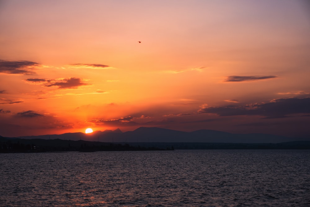 the sun is setting over a body of water