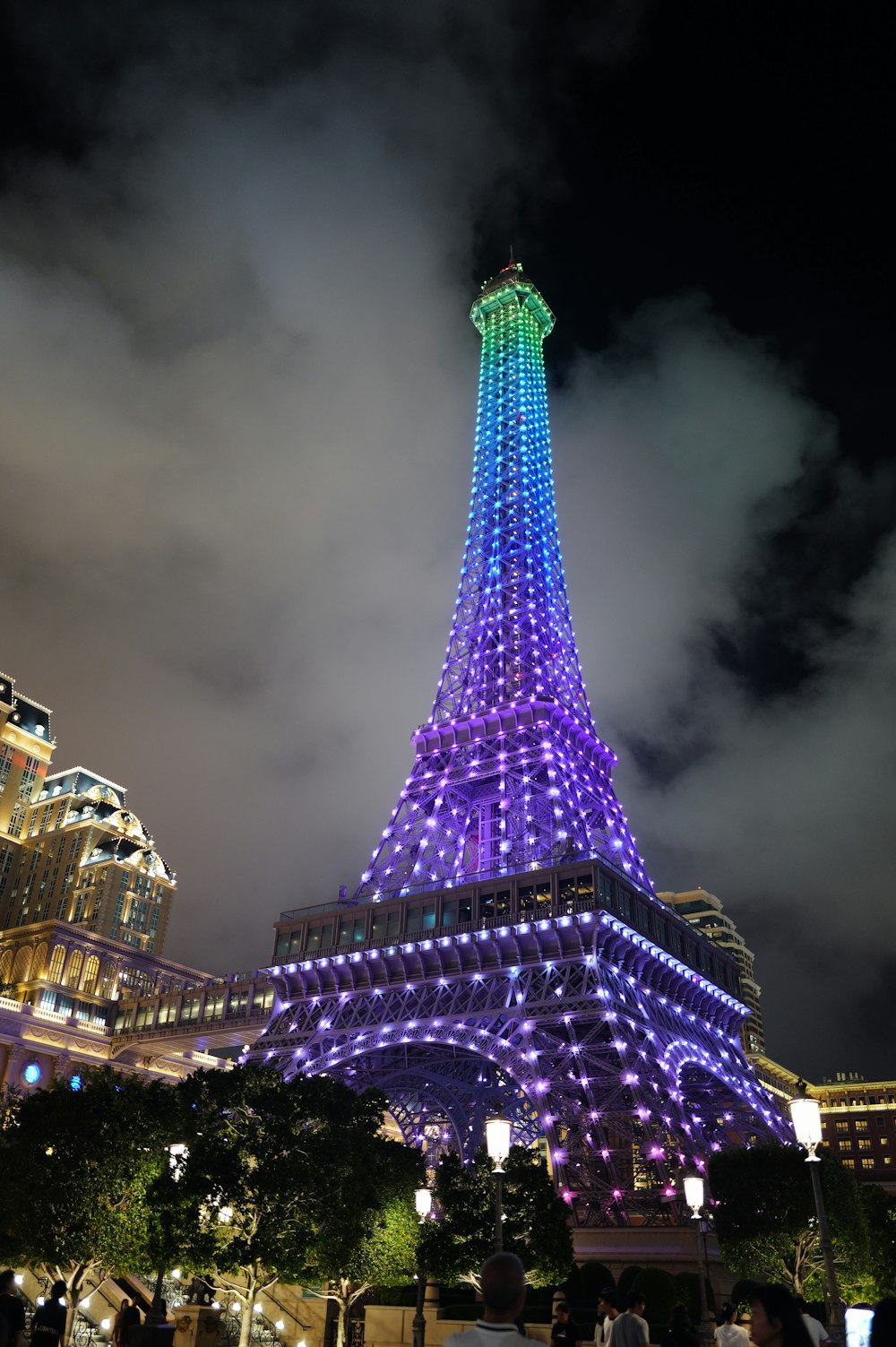 the eiffel tower lit up in blue and purple