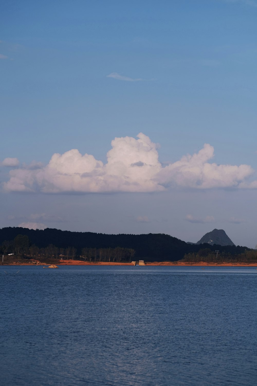 a large body of water with a mountain in the background