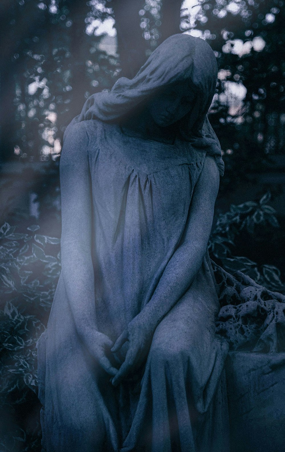 Una estatua de una mujer sentada en un jardín