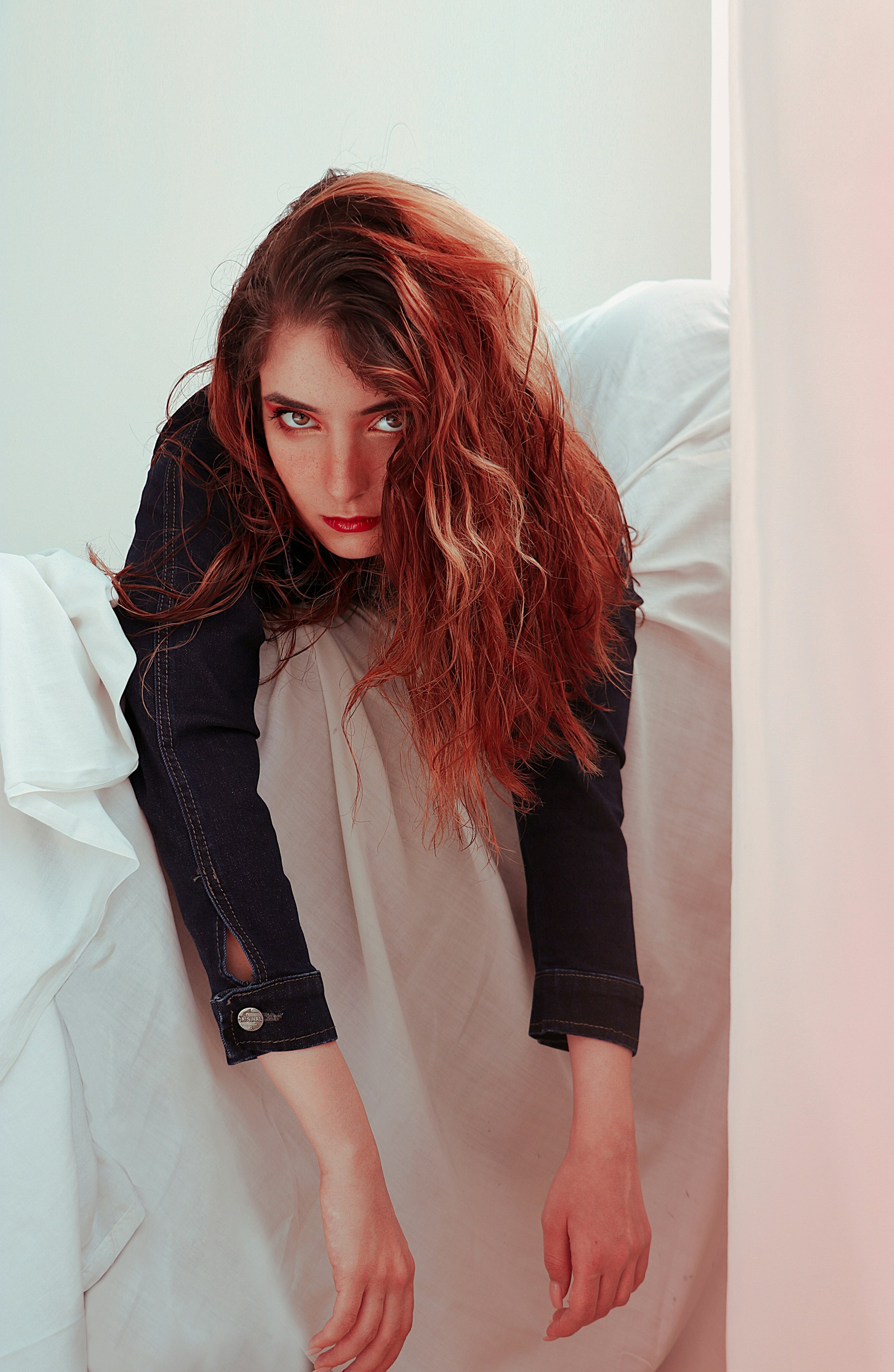 Una donna seduta su una sedia bianca con i capelli che soffiano al vento