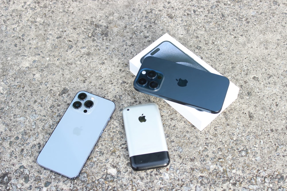 three iphones sitting on the ground next to each other