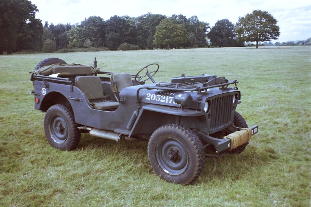 an old army jeep is parked in a field