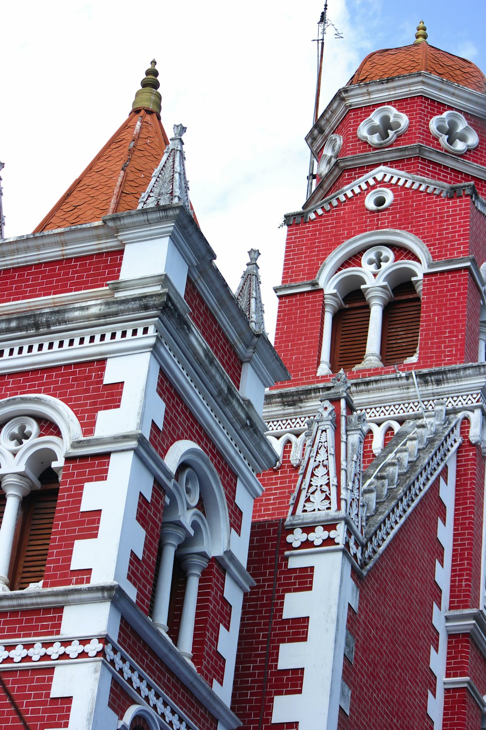 a tall red and white building with a clock on it's side