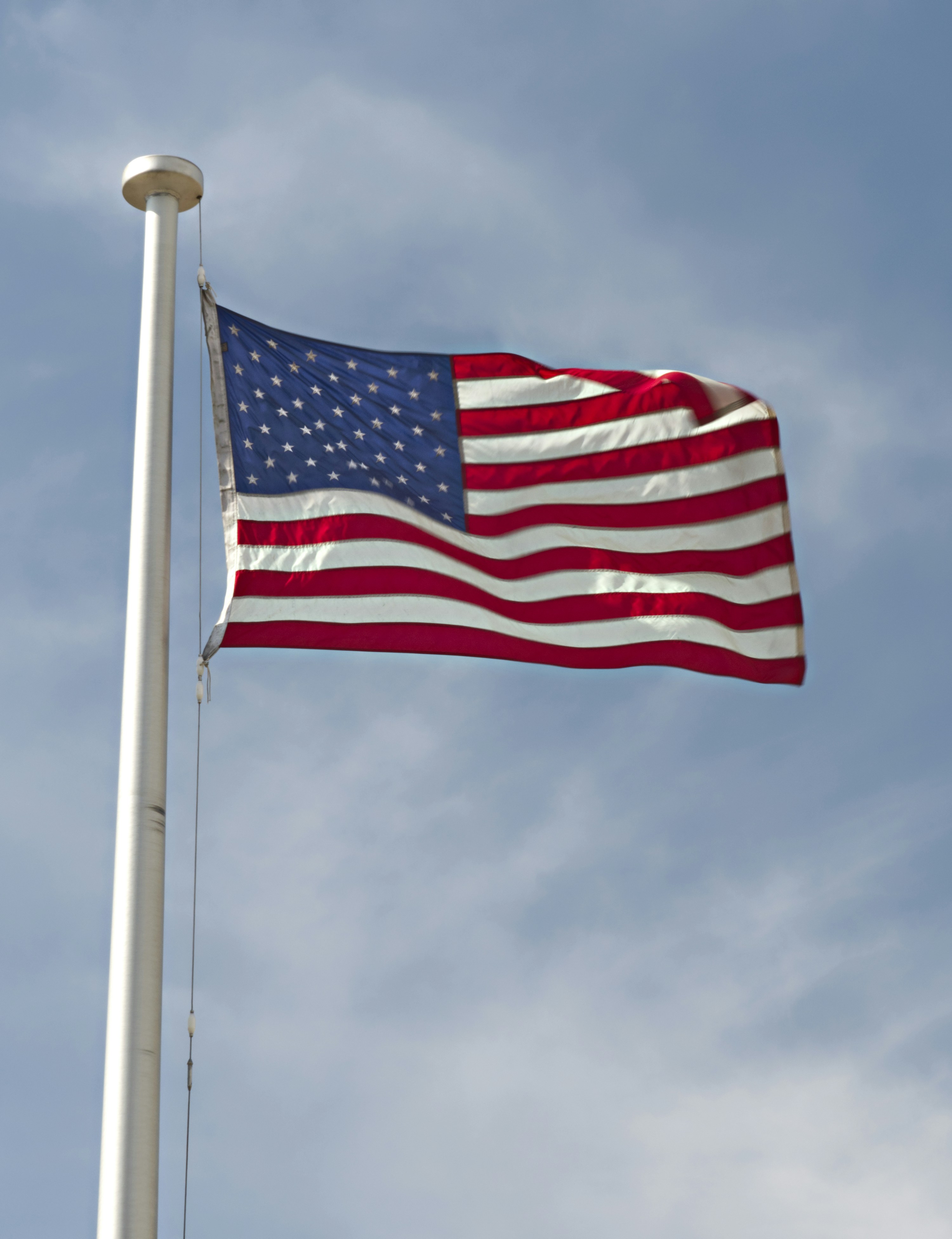 a large american flag flying in the wind