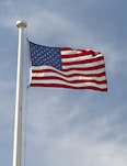 a large american flag flying in the wind