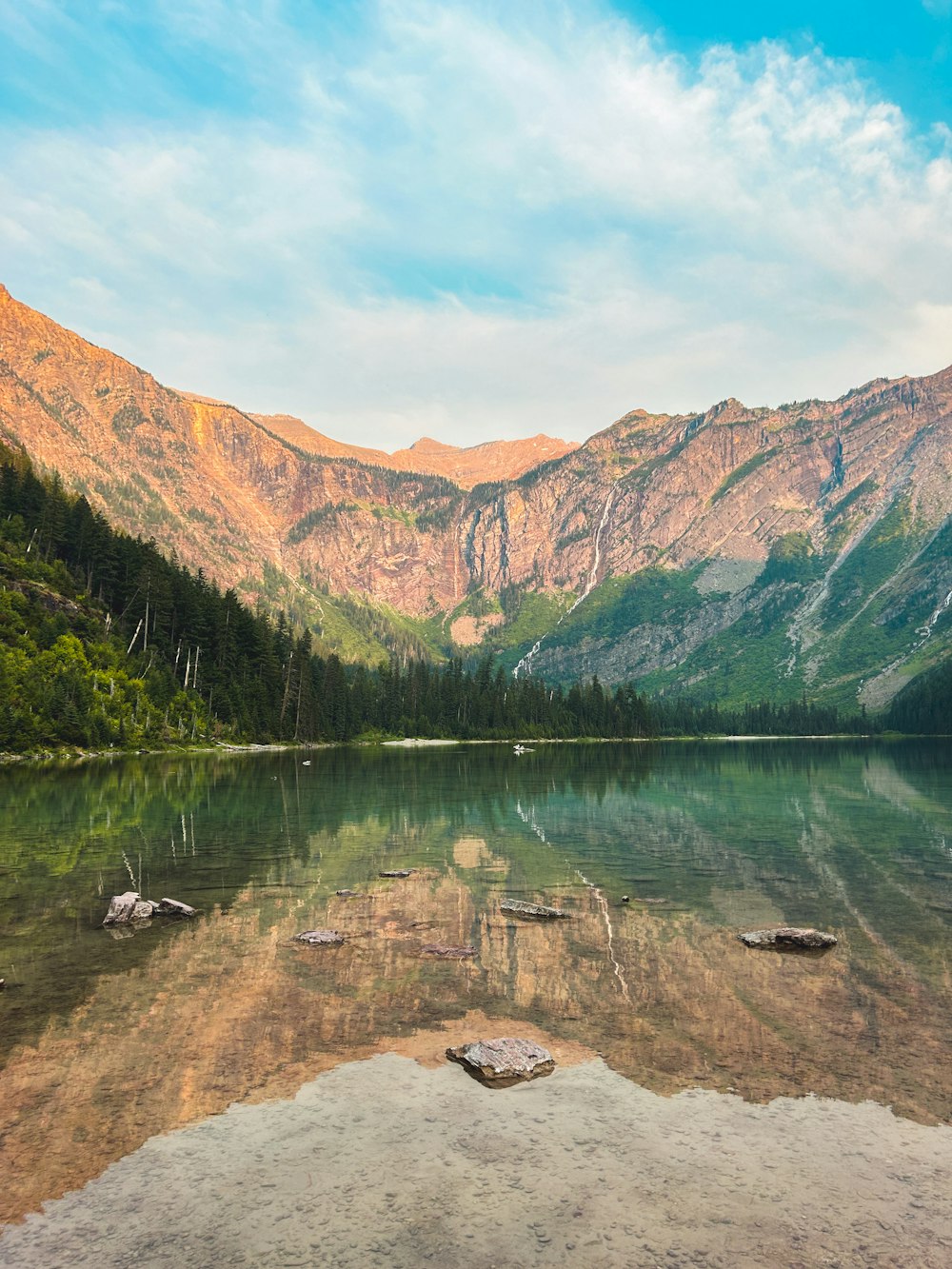 a lake surrounded by mountains in the middle of a forest