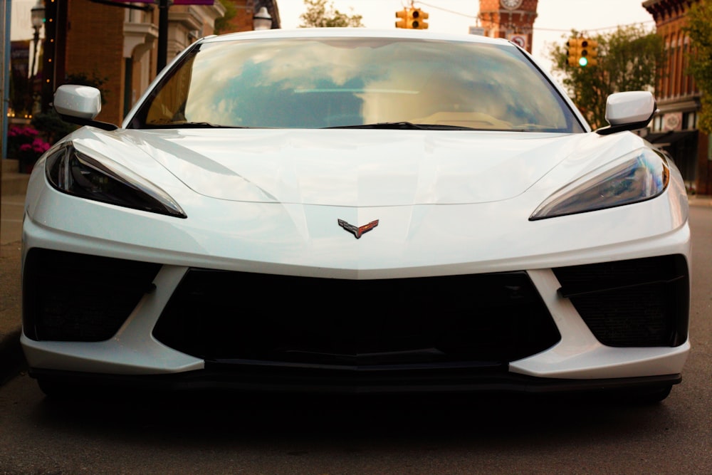 a white sports car parked on the side of the road