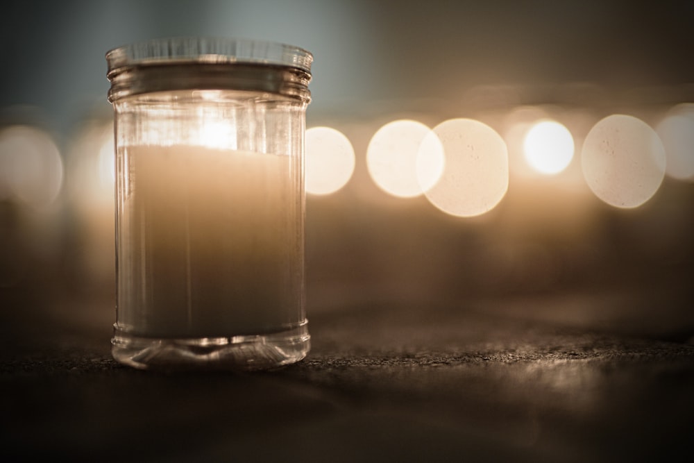 a glass jar with a candle inside of it