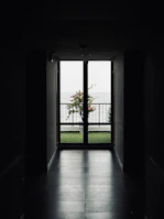 an open door leading to a balcony with a view of the ocean