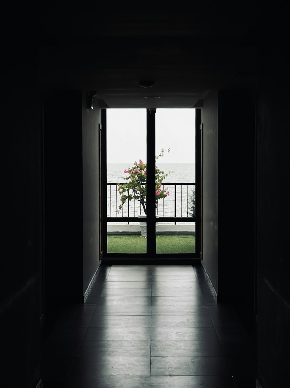 an open door leading to a balcony with a view of the ocean