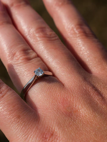 Close-up of a delicate custom engagement ring with a sparkling diamond centerpiece set in a handcrafted gold band.