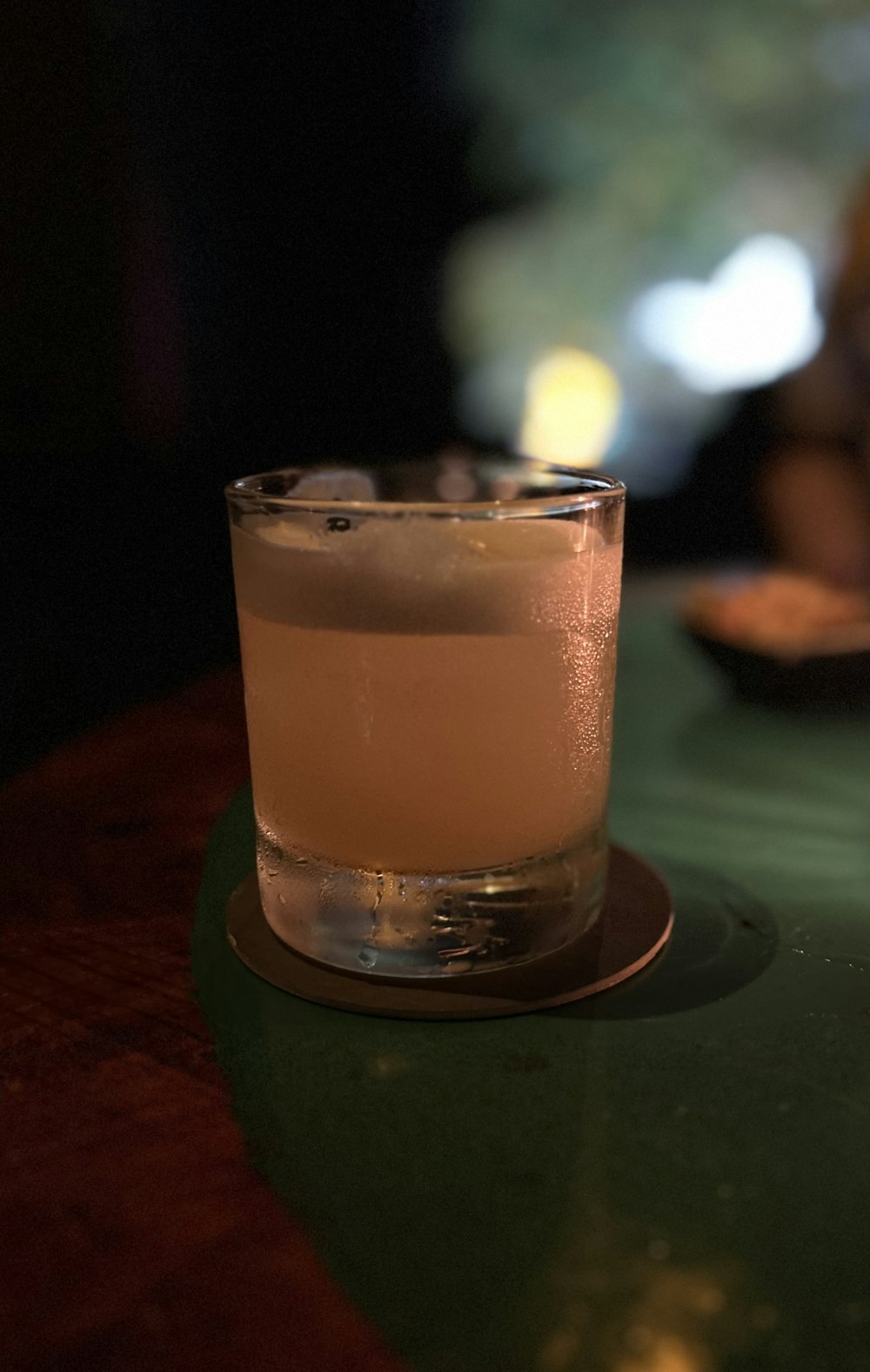 a glass of alcohol sitting on top of a table