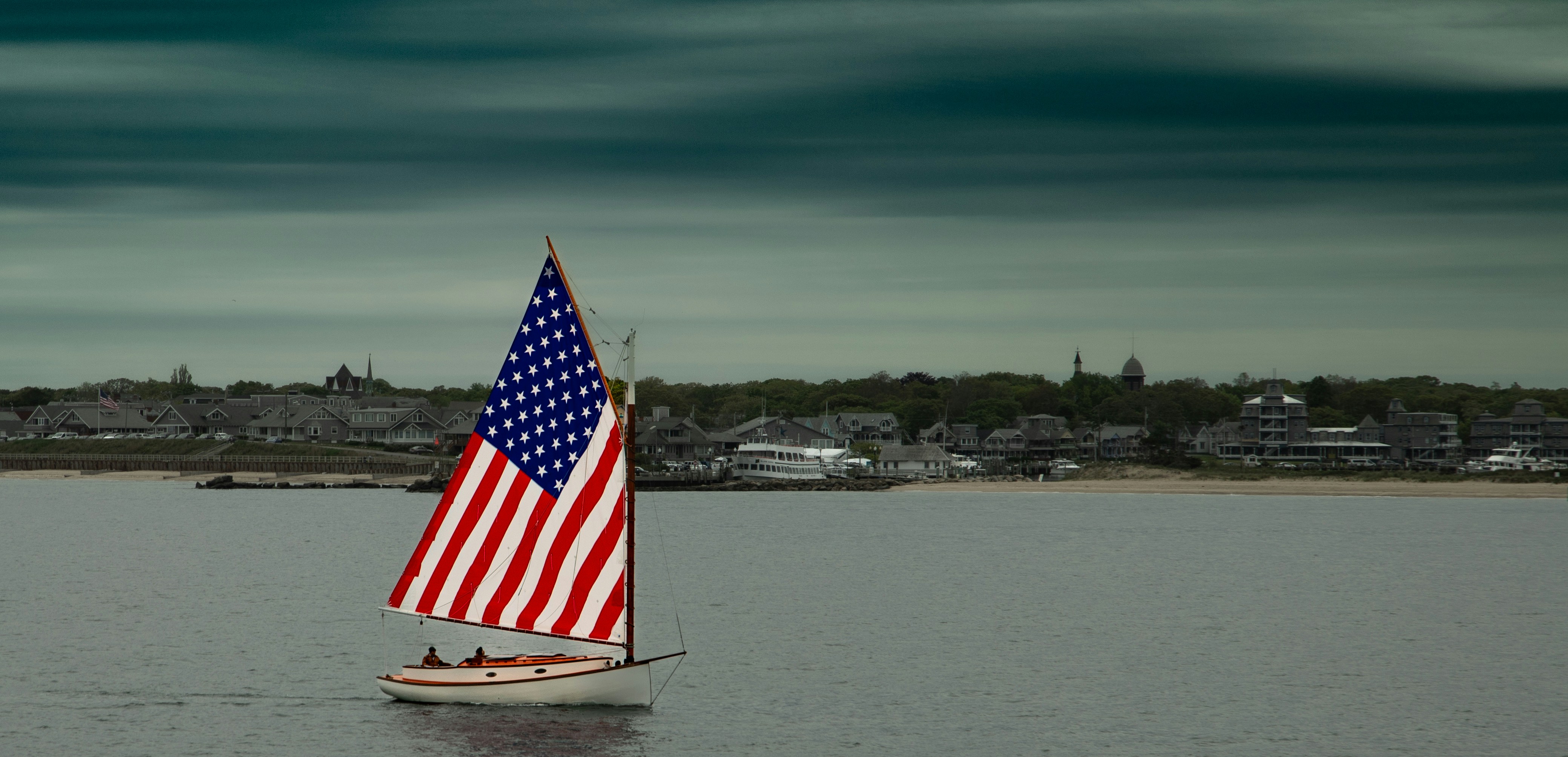 a small sailboat with an american flag on it