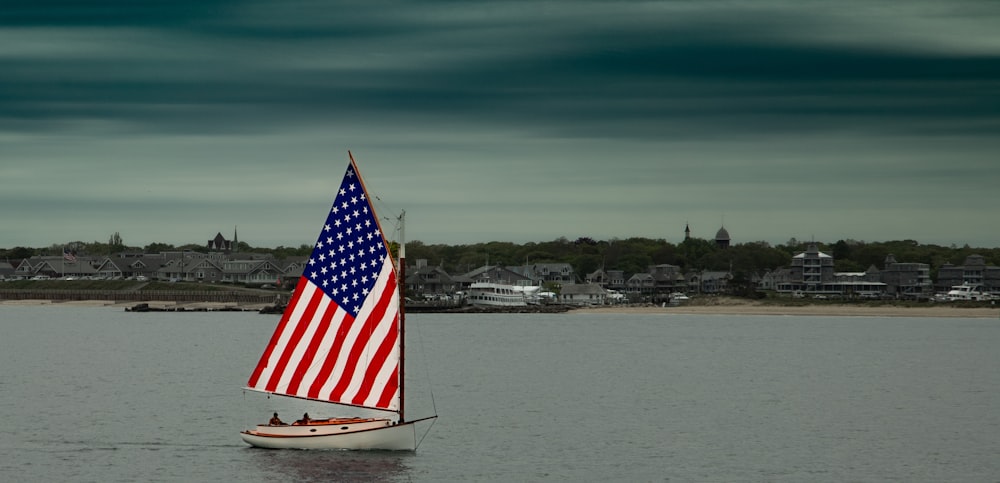 a small sailboat with an american flag on it