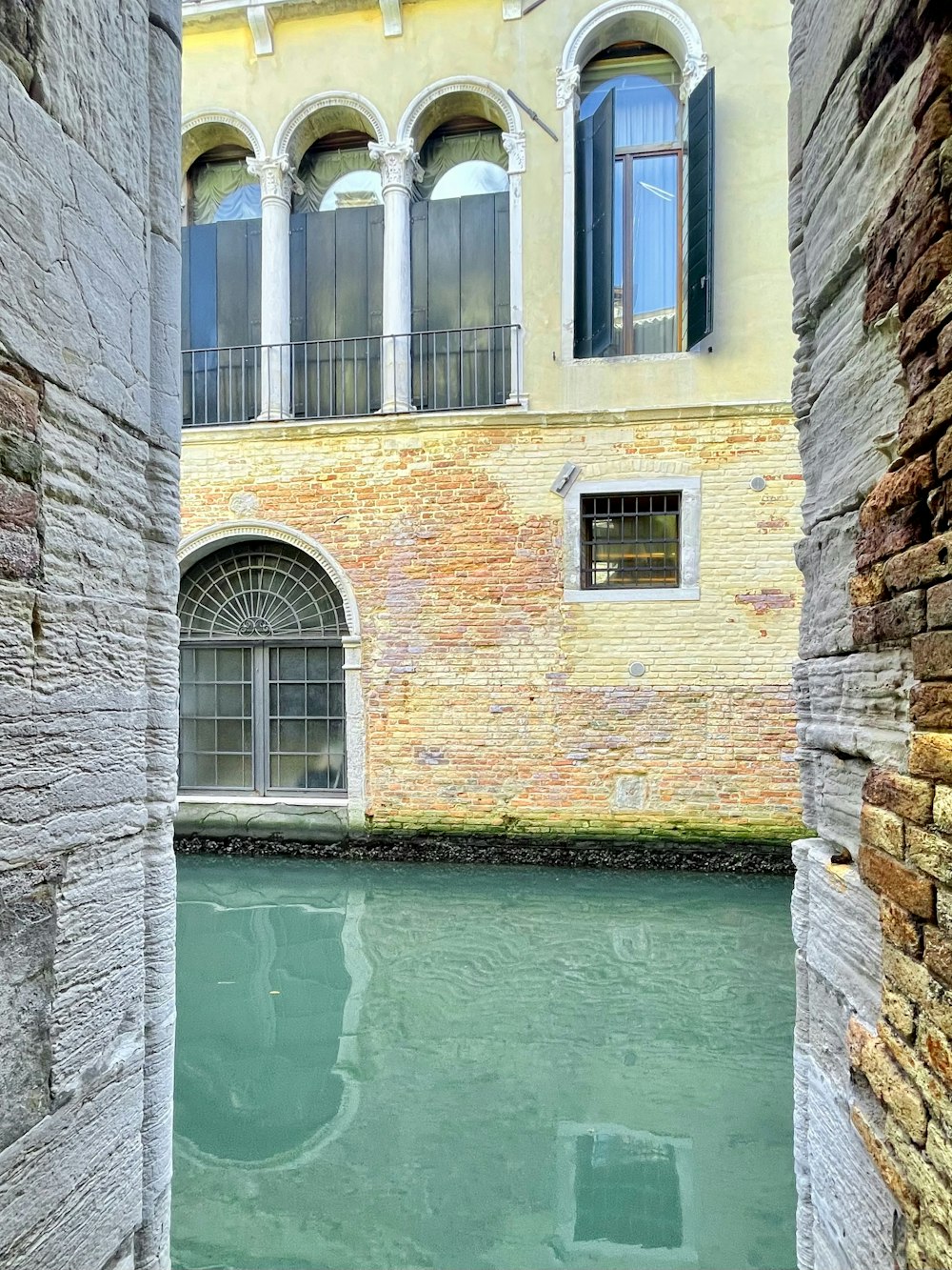 a narrow canal with a building in the background