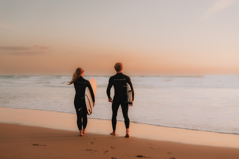 a couple of people that are standing in the sand