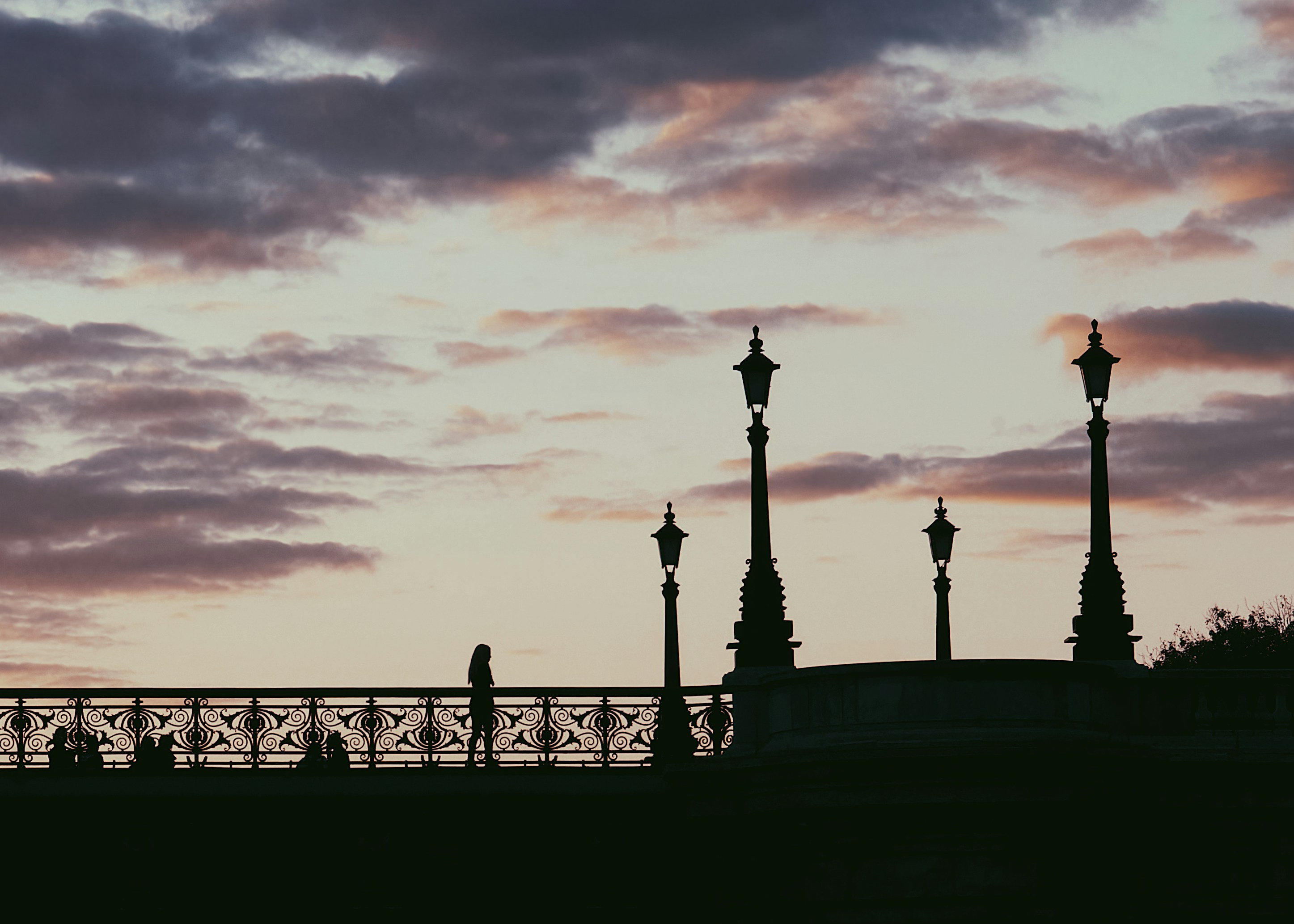 a couple of street lights sitting on top of a bridge, 