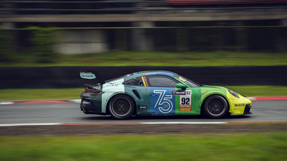 a green and yellow car driving on a race track