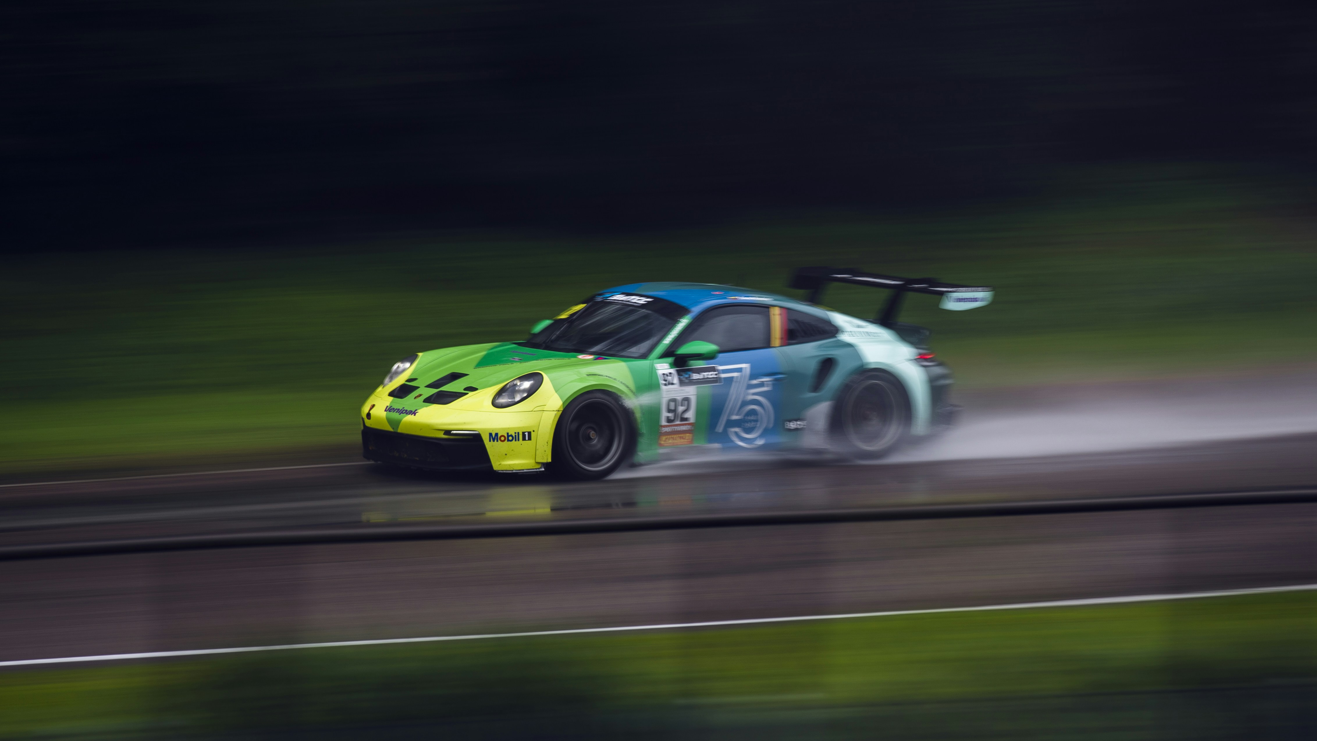 A green and blue race car driving on a track photo – Free Car Image on ...