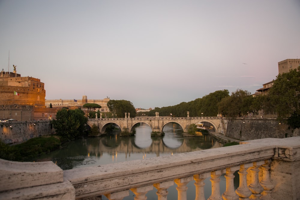 a bridge over a river next to a tall building