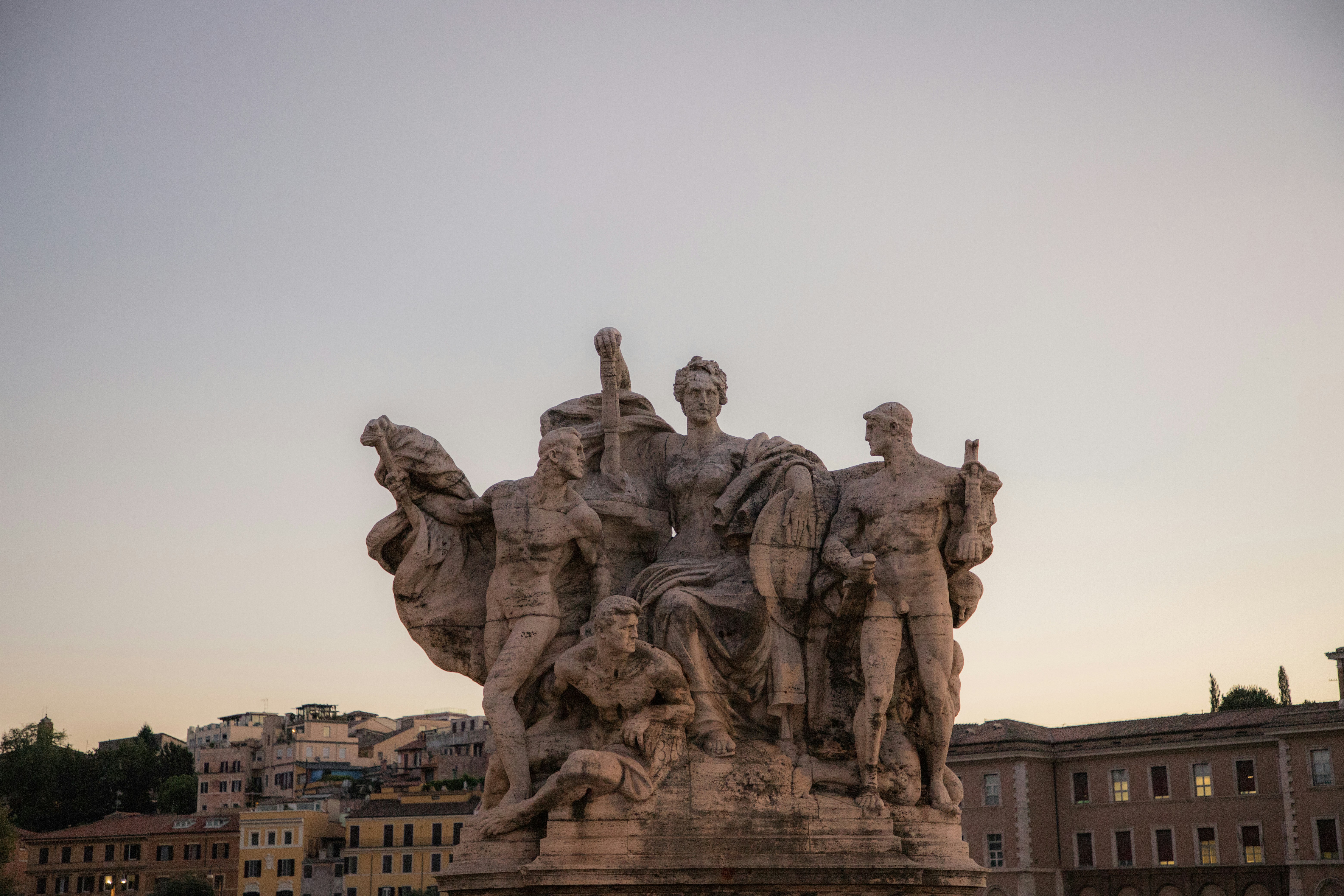 a statue of a group of people with a building in the background