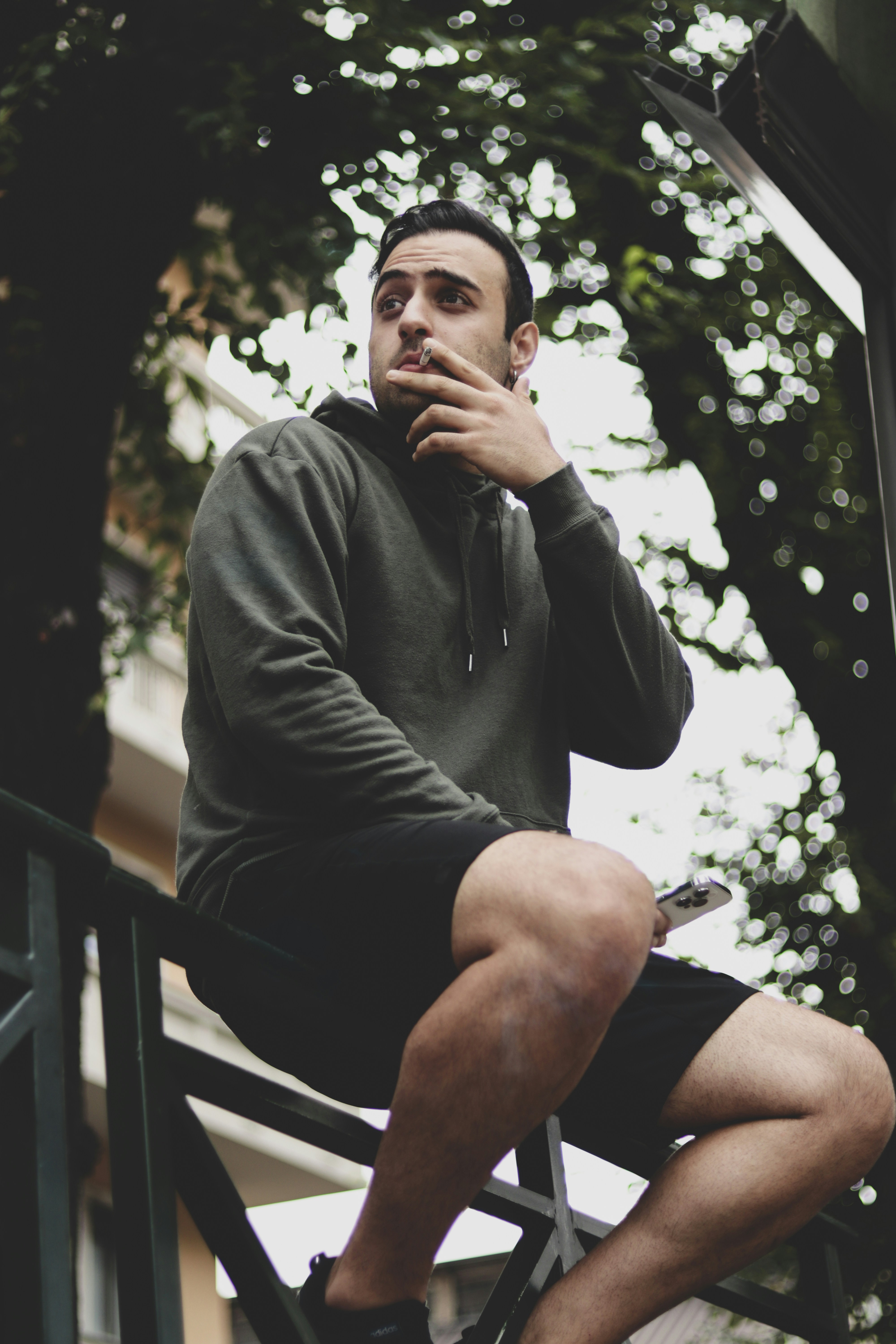 a man sitting on a chair smoking a cigarette