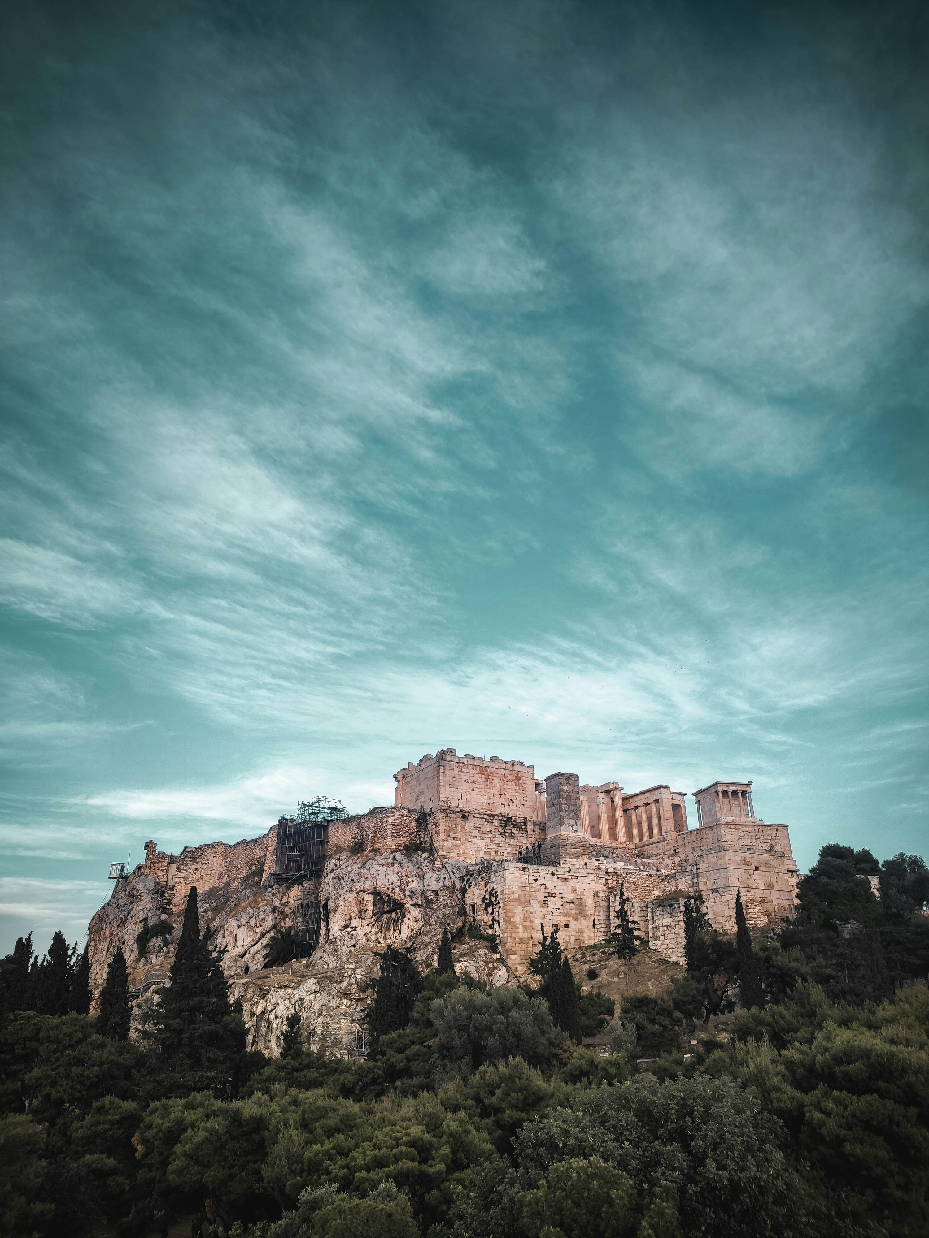 a large building sitting on top of a lush green hillside